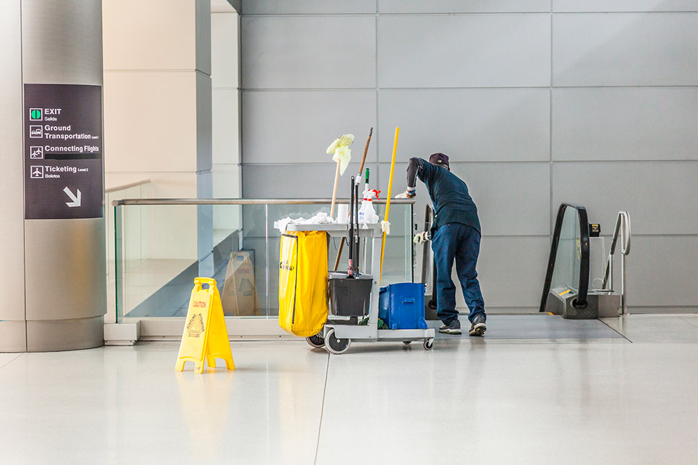 janitor cleaning airport escalator