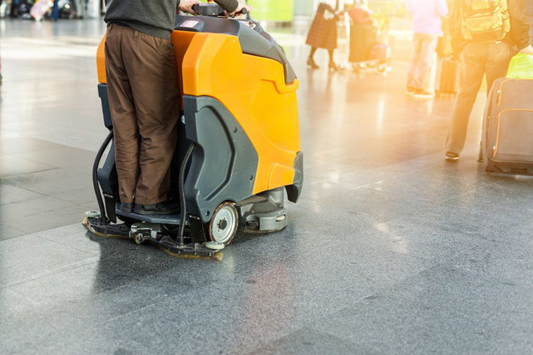 janitor driving a floor waxer